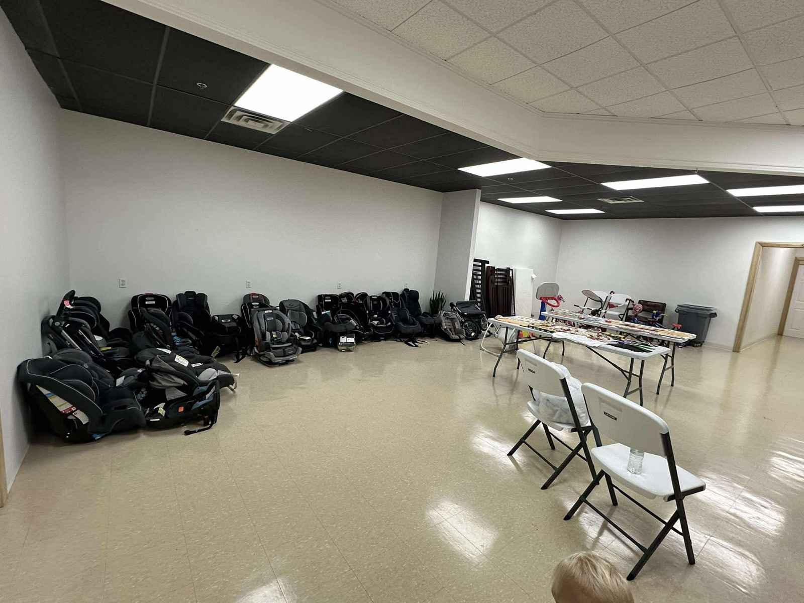 Rows of donated child car seats lined up along a wall, ready for families